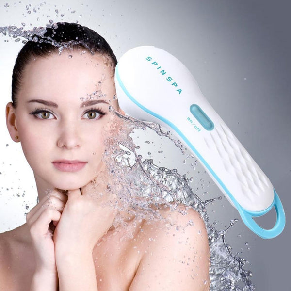Woman using a SpinSpa facial cleansing device with water splashes around her face.