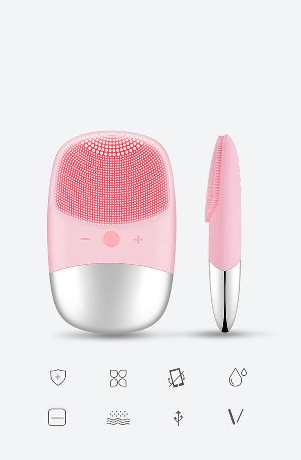 Pink facial cleansing brush with silver base on a white background