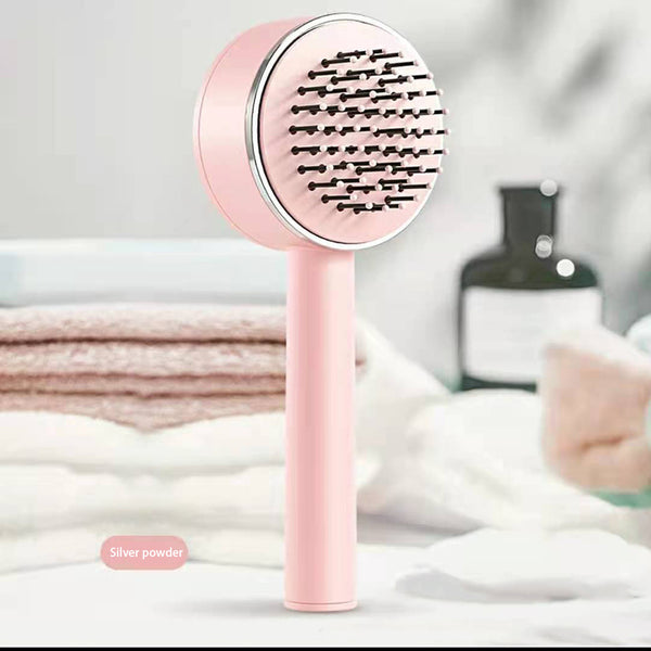 Pink handheld shower head with black bristle pattern on a blurred bathroom background