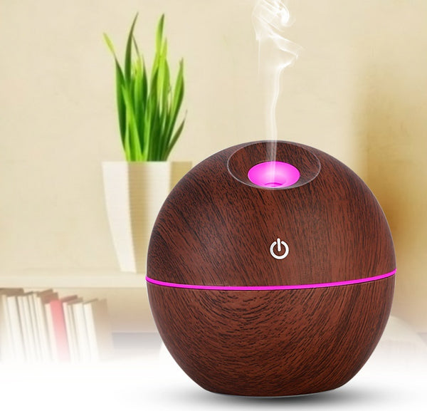 Wooden diffuser with pink light and power symbol on a neutral background