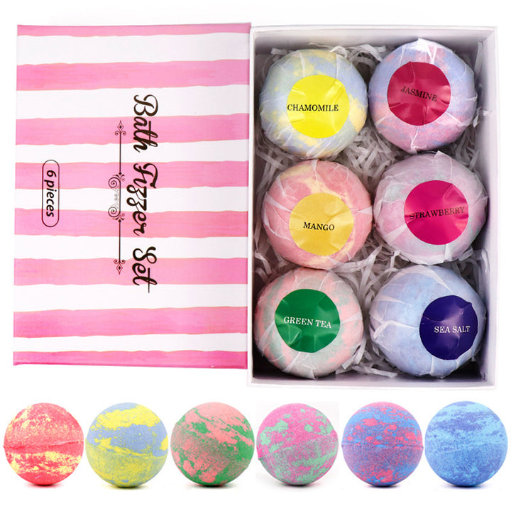 Set of bath bombs with labeled colors next to a striped box packaging.