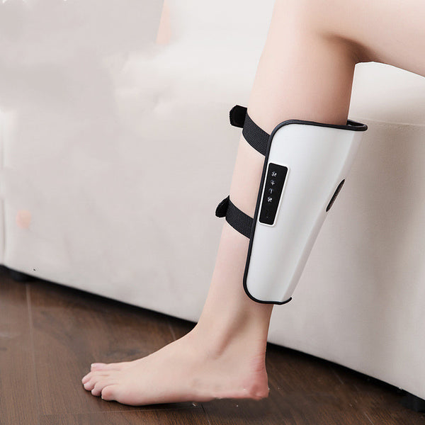 Person using a white and black leg massager on a wooden floor.
