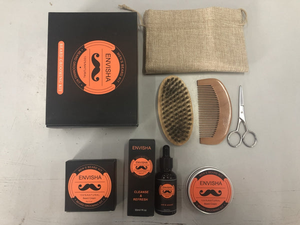 Set of Envisha grooming products including a box, brush, comb, scissors, and bottles on a light surface.