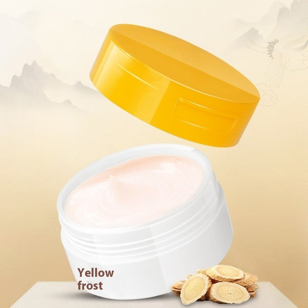 White jar with yellow lid containing a cream-like substance on a beige background